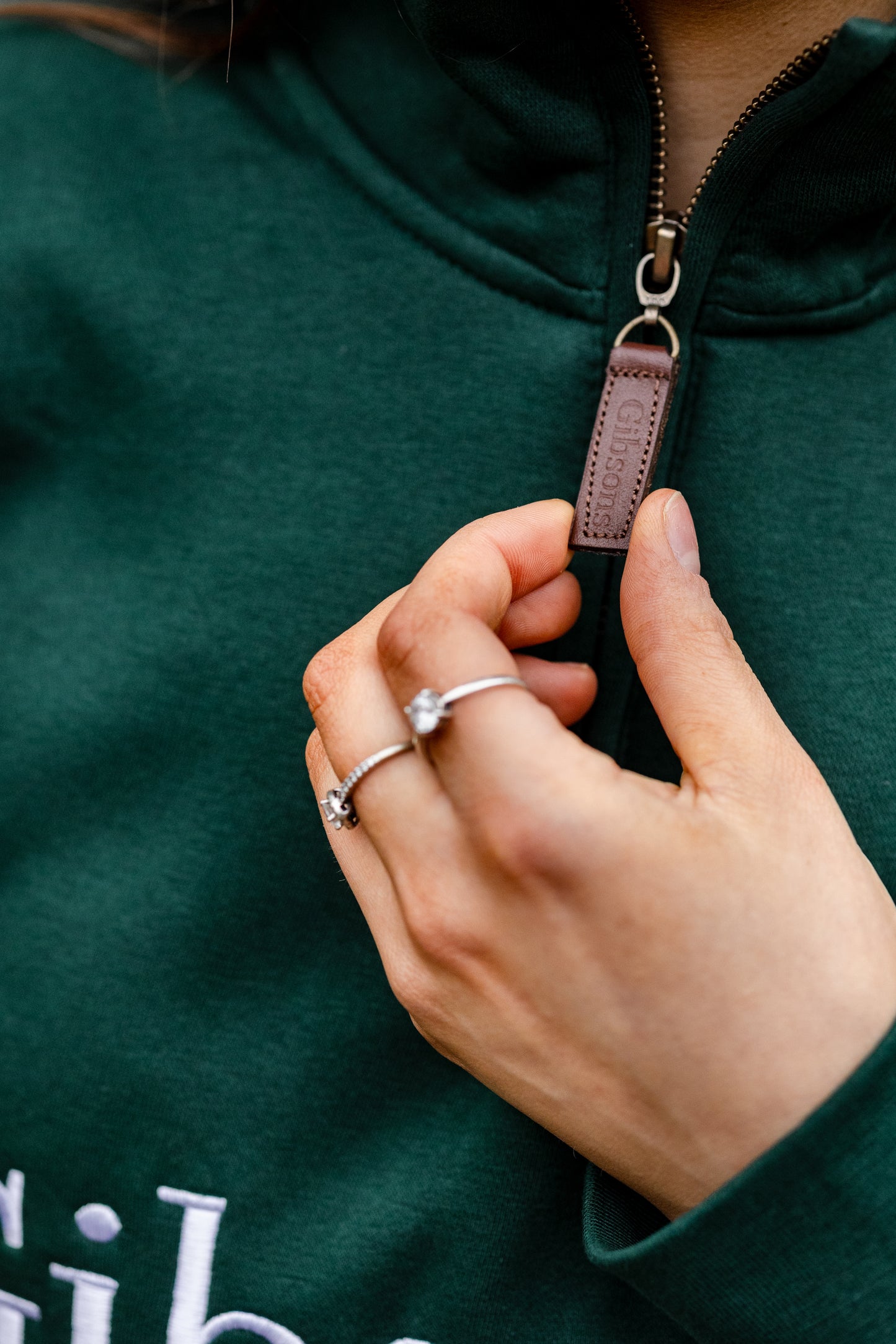 Person wearing a green swearshirt with a zipper