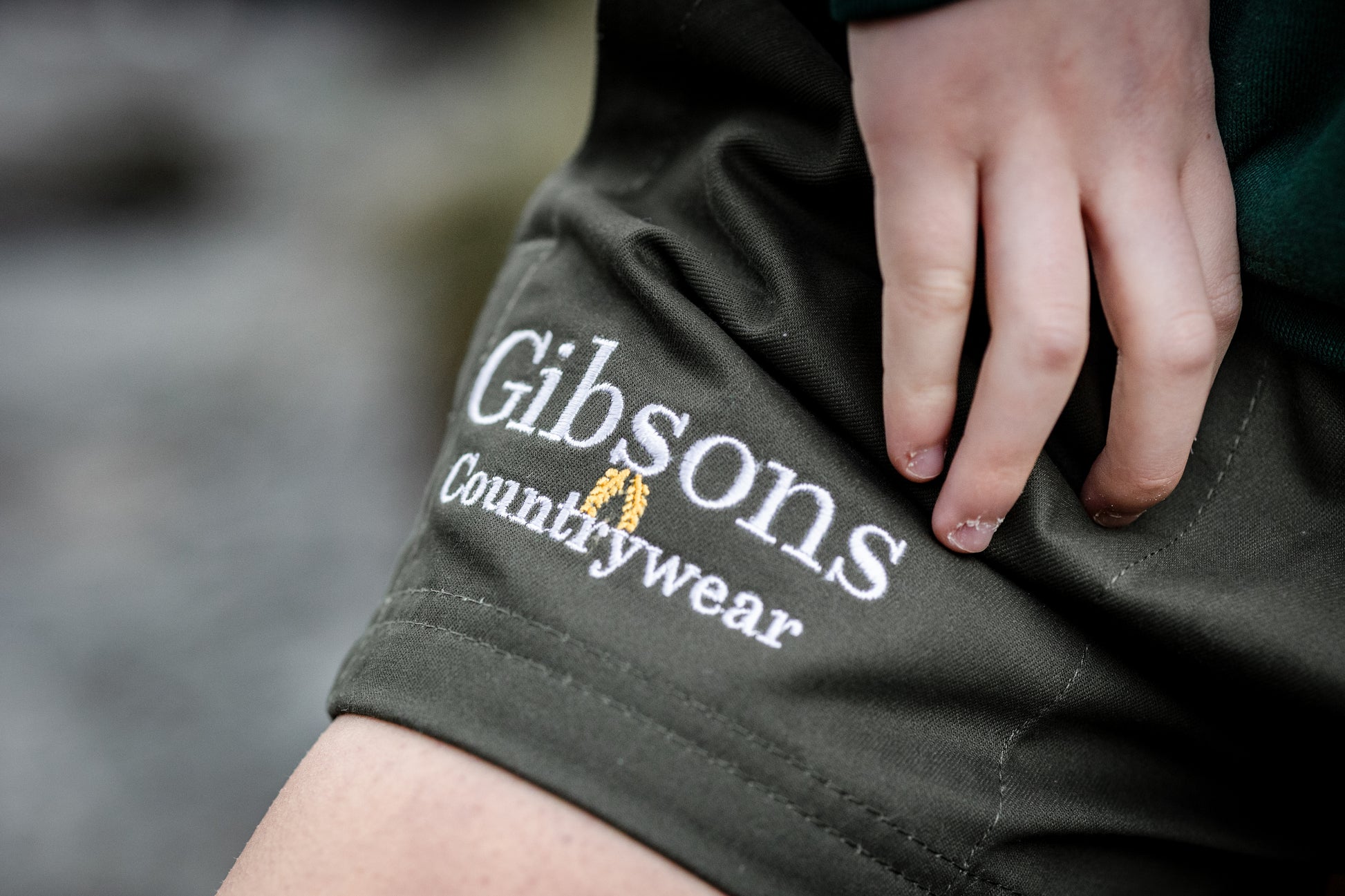 Gibsons Countrywear logo on a person's shorts with a blurred natural background