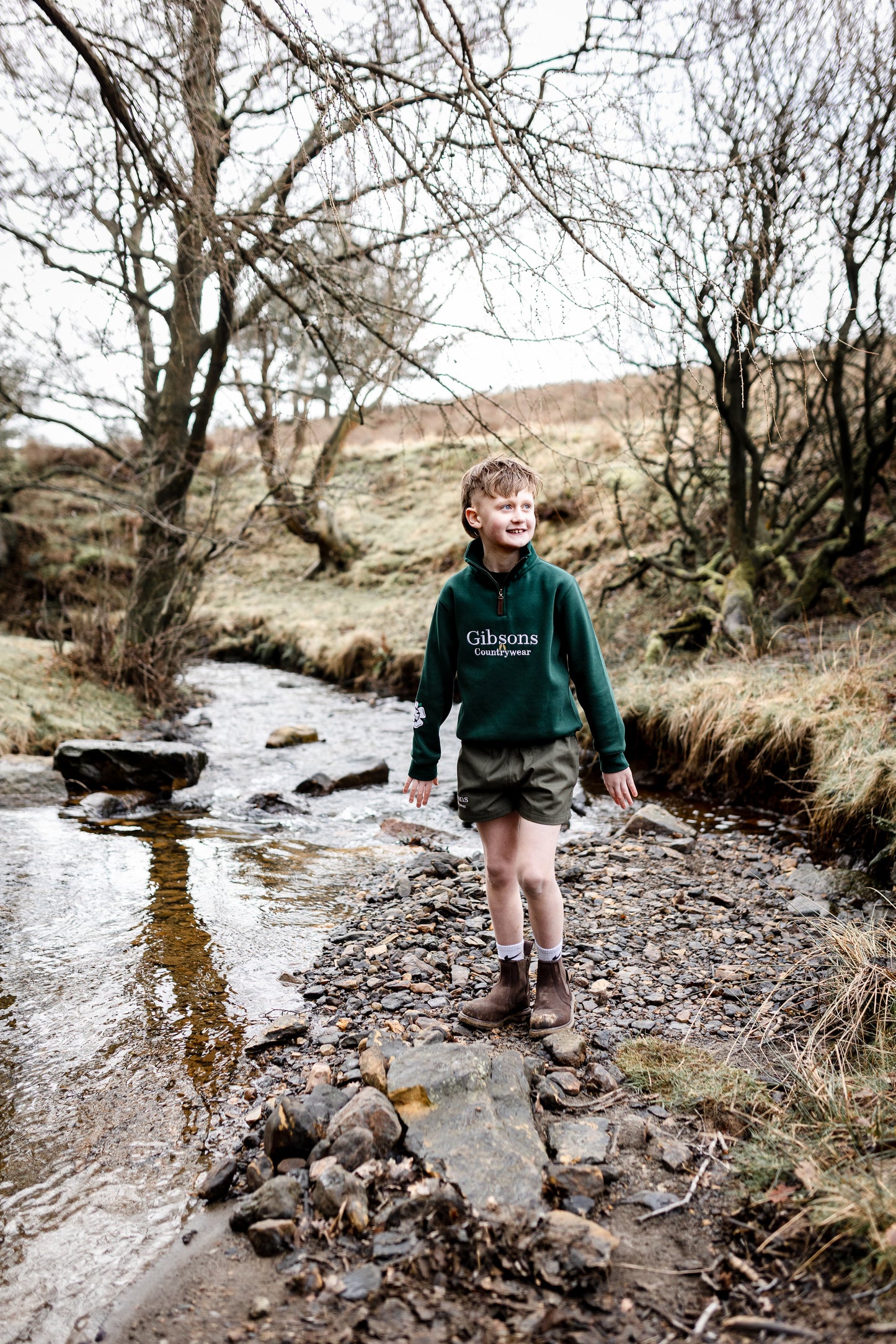 Person walking across a stream in a natural landscape