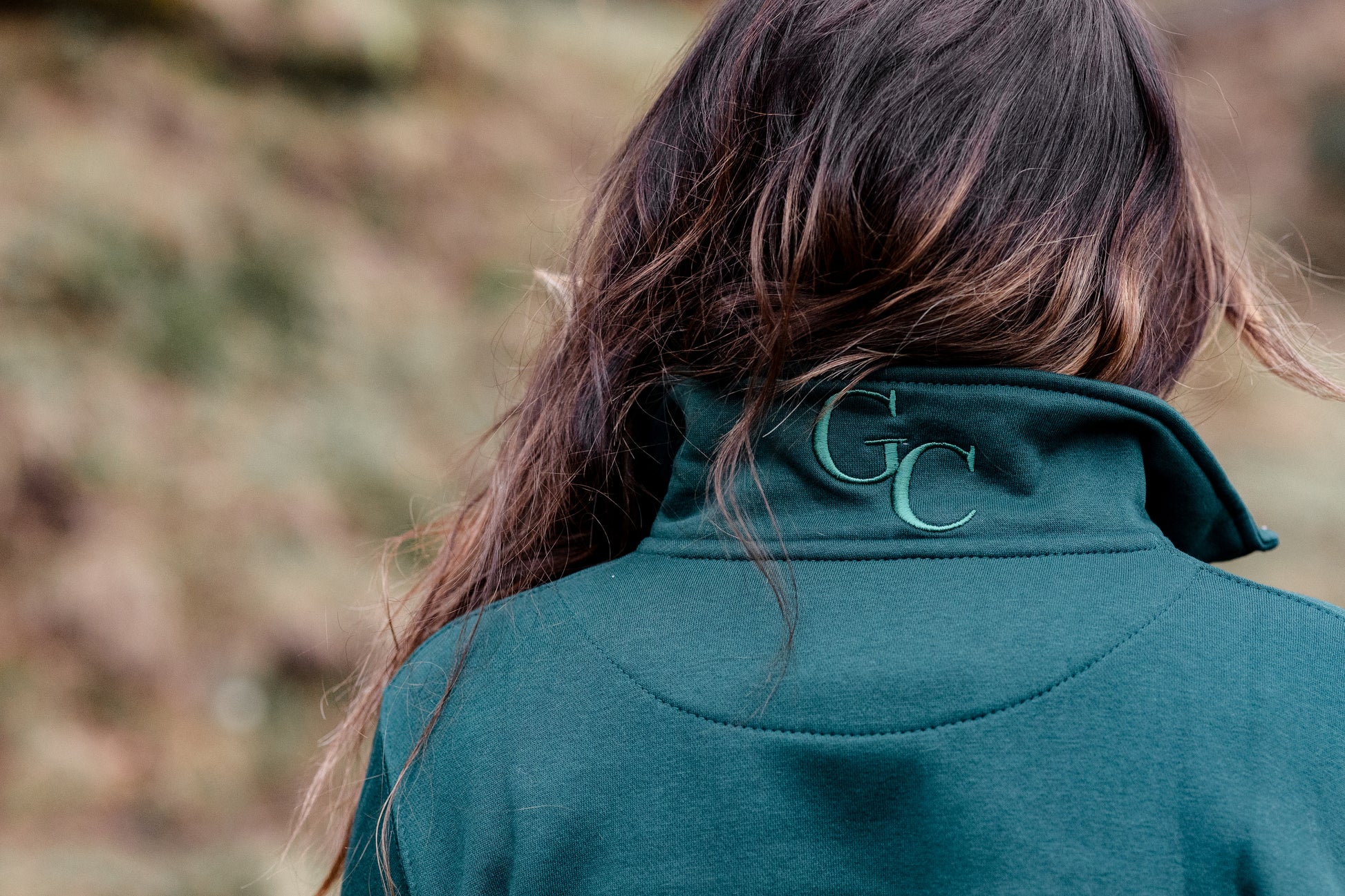 Person wearing Gibsons Country Wear with a logo on the back, standing in a natural setting.