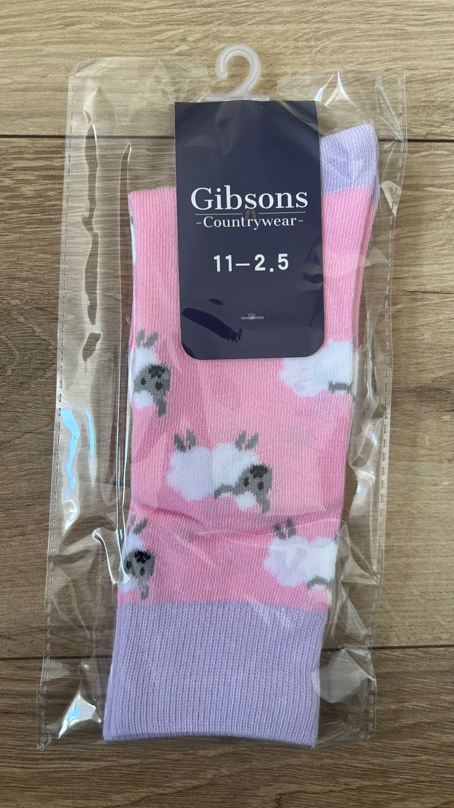 Pink socks with cloud and animal pattern in packaging, brand 'Gibsons' visible