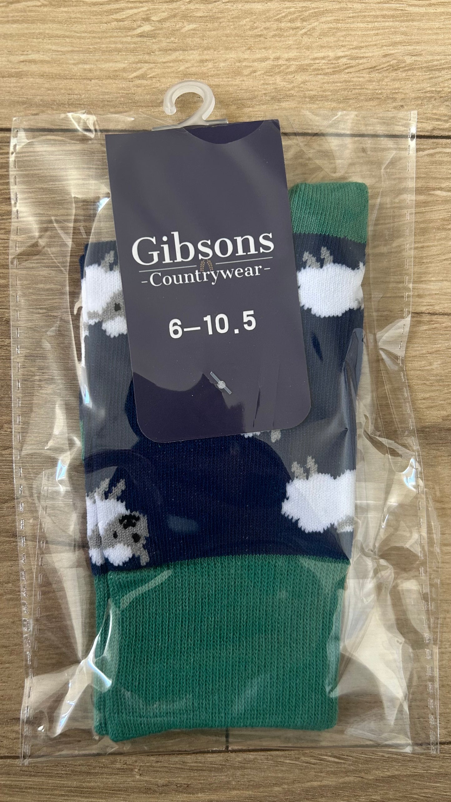 Pair of socks with a 'Gibsons Countrywear' label on a wooden surface